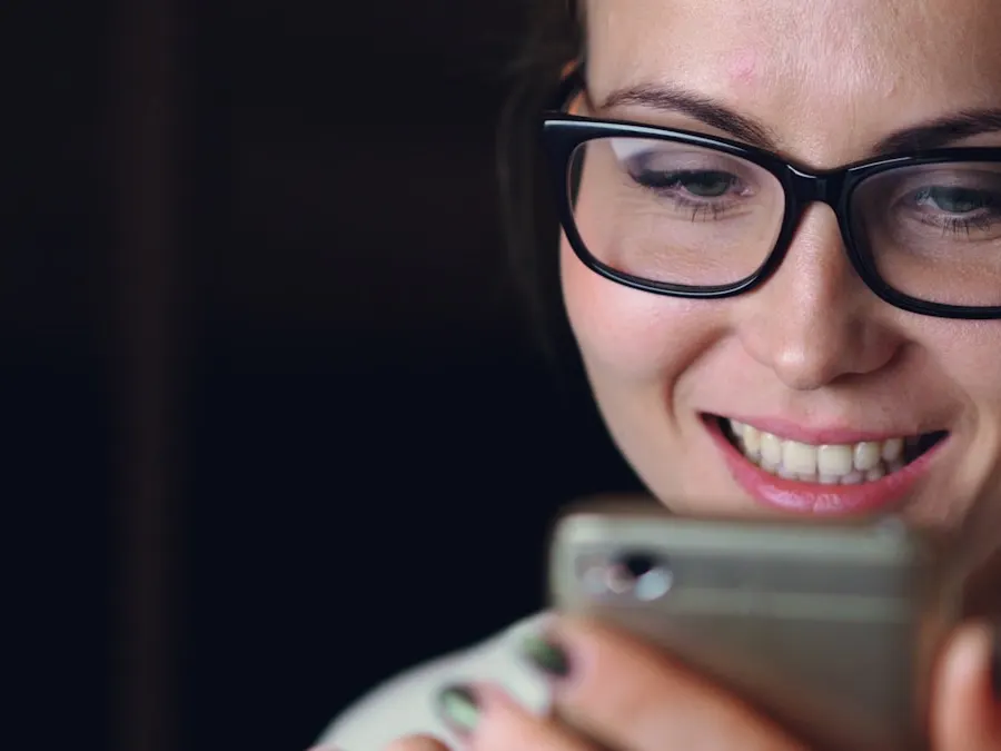 Smiling woman wearing glasses reading a message on her phone