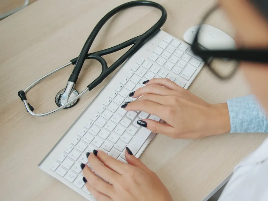 Provider typing at a laptop with a stethoscope beside the keyboard