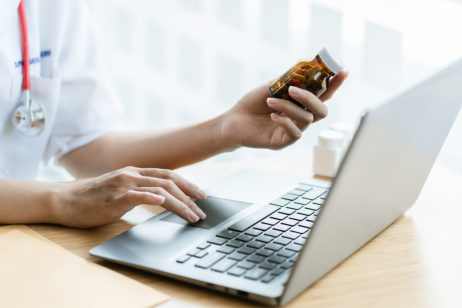 doctor on a laptop helping with online prescriptions with a patient